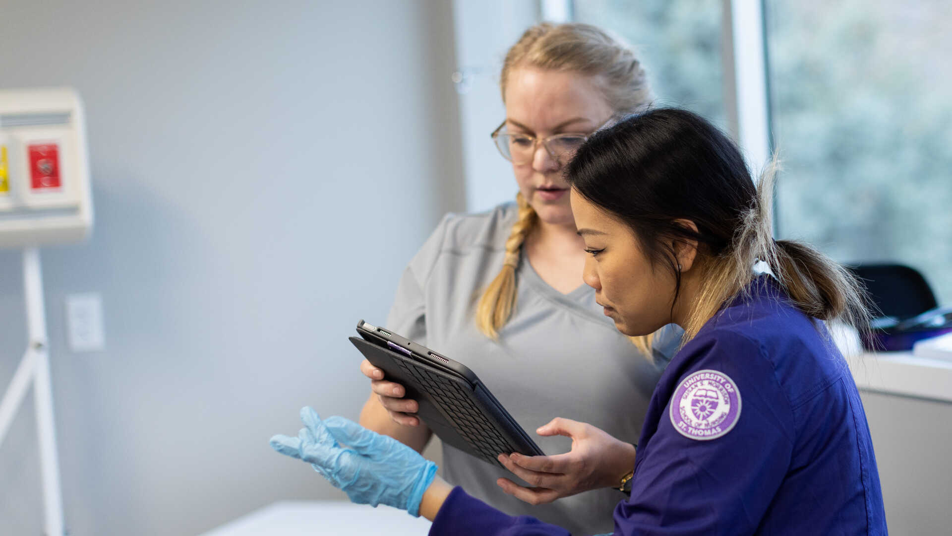 Two female nursing students working on an iPad