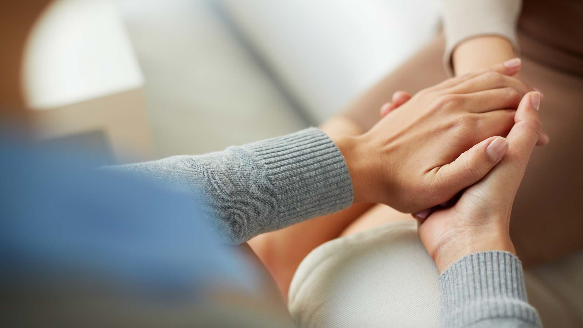 Counselor holds patient's hand 