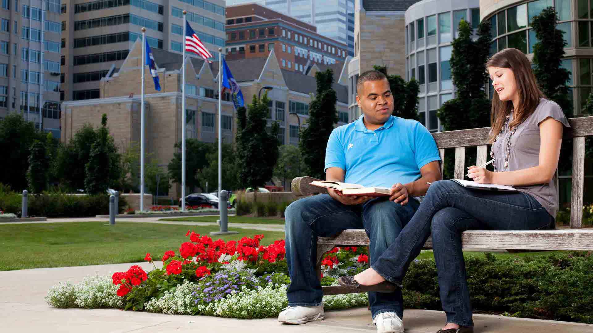 Two students sit outside on Minneapolis campus