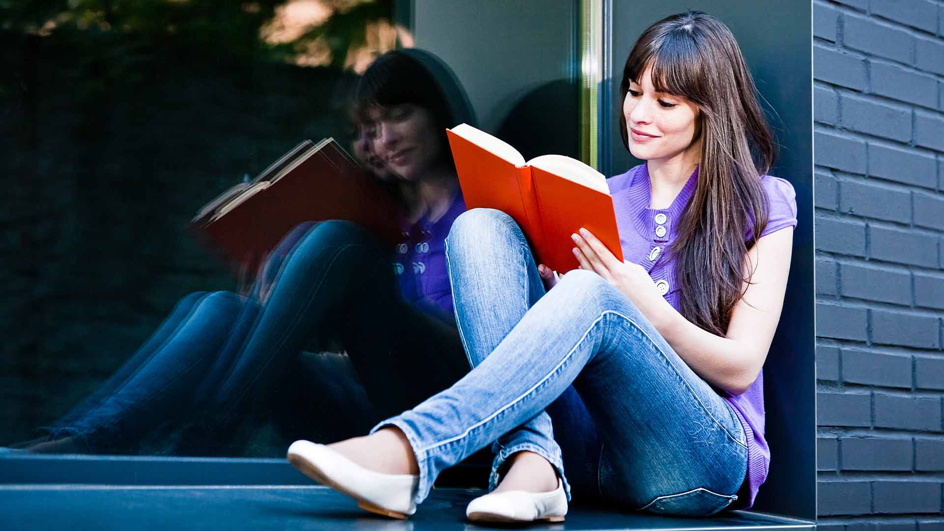 woman reads a book outside