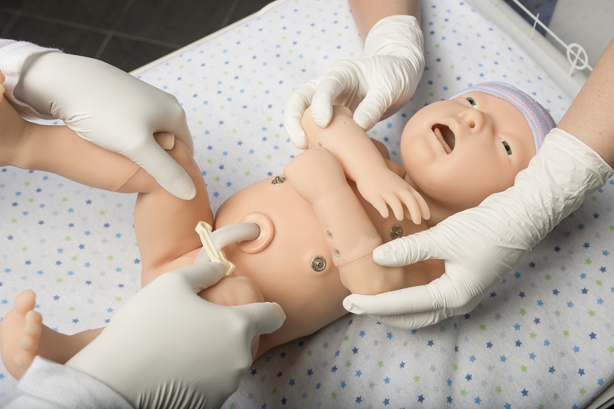 Nursing students work with a baby simulation mannequin.