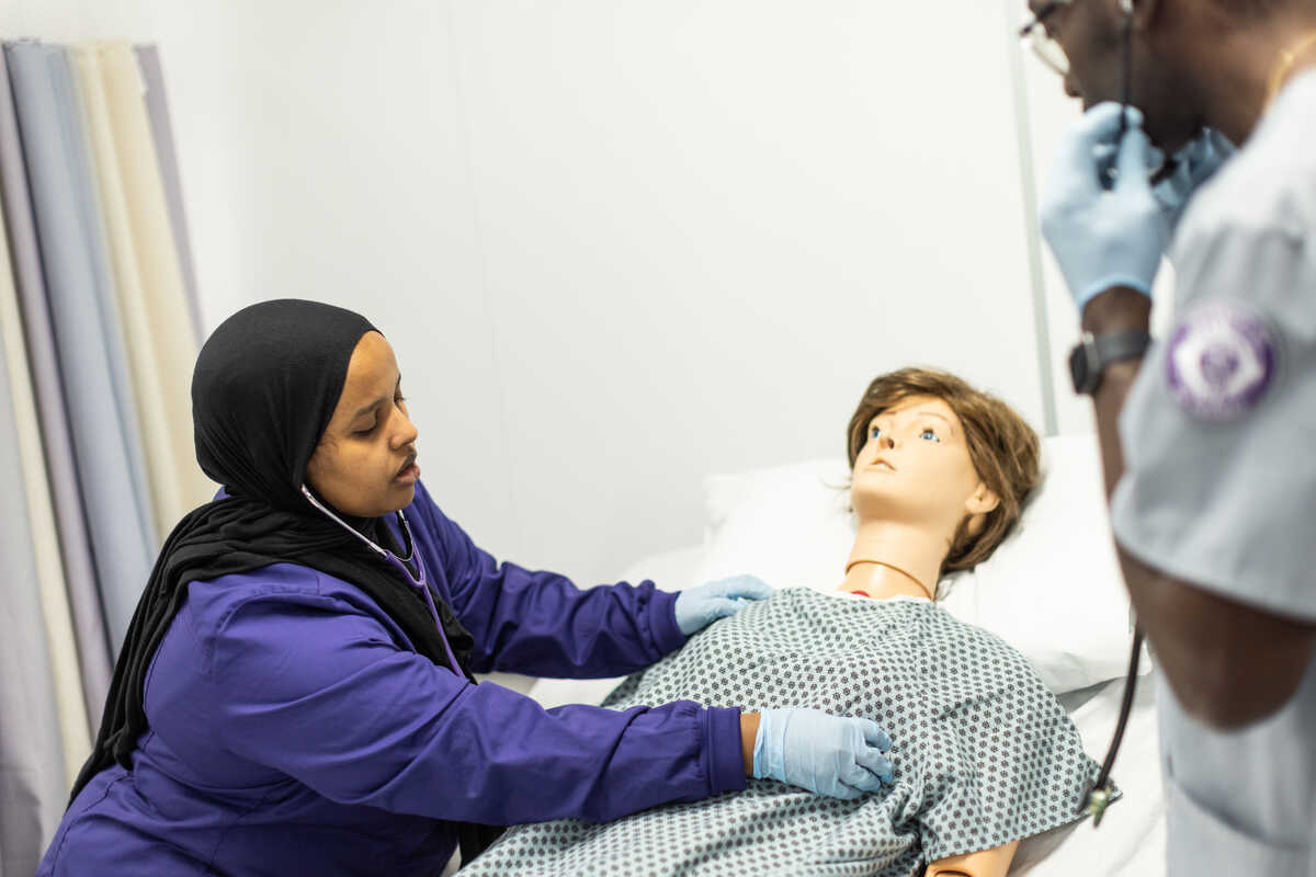Two nursing students working with a simulator