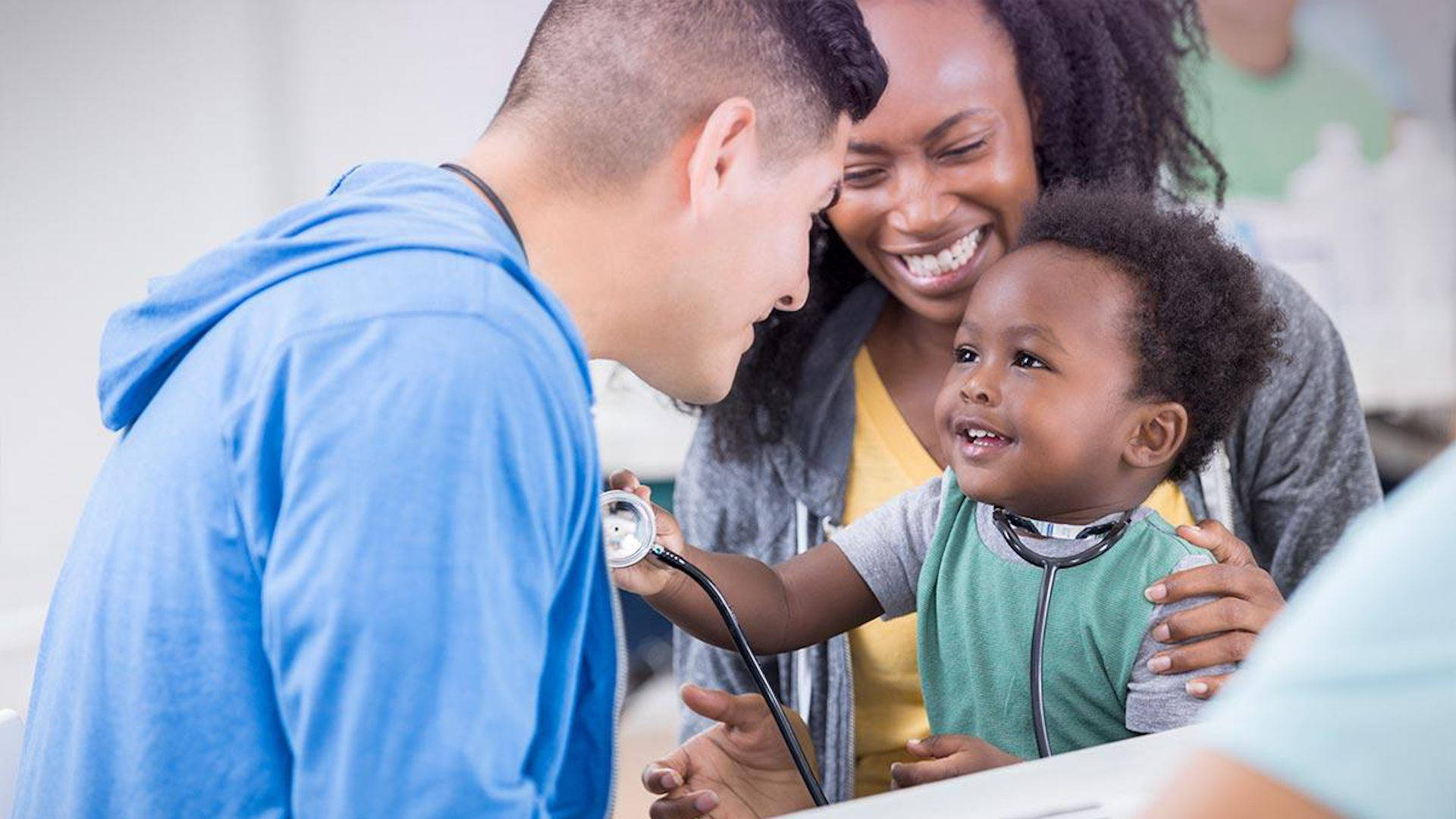 a male nurse, a mother, and a baby smiling