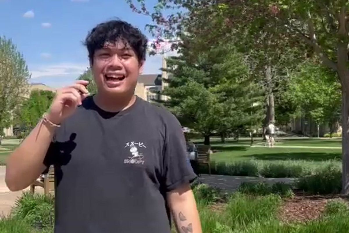 Student smiling at camera outside