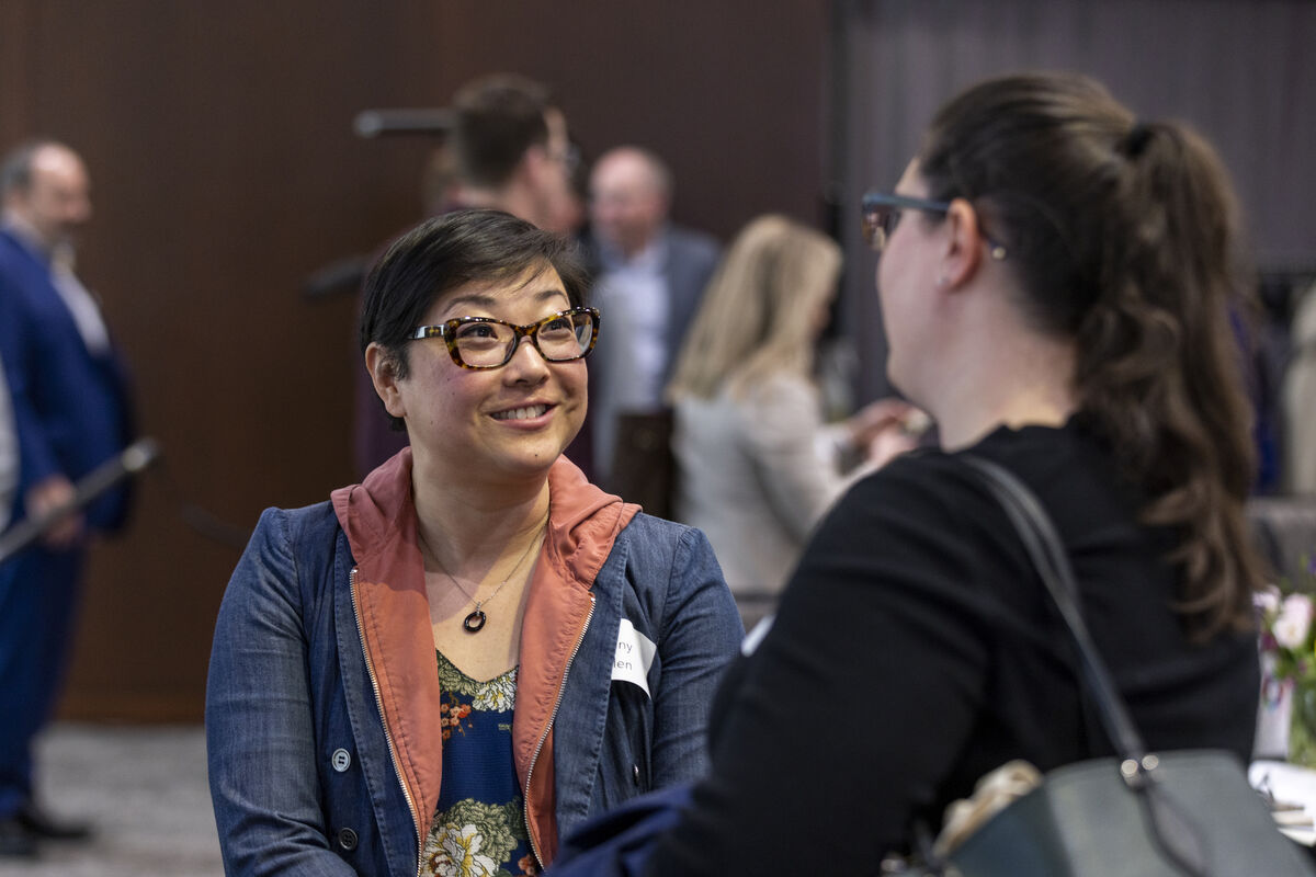 two women talking at a professional gathering