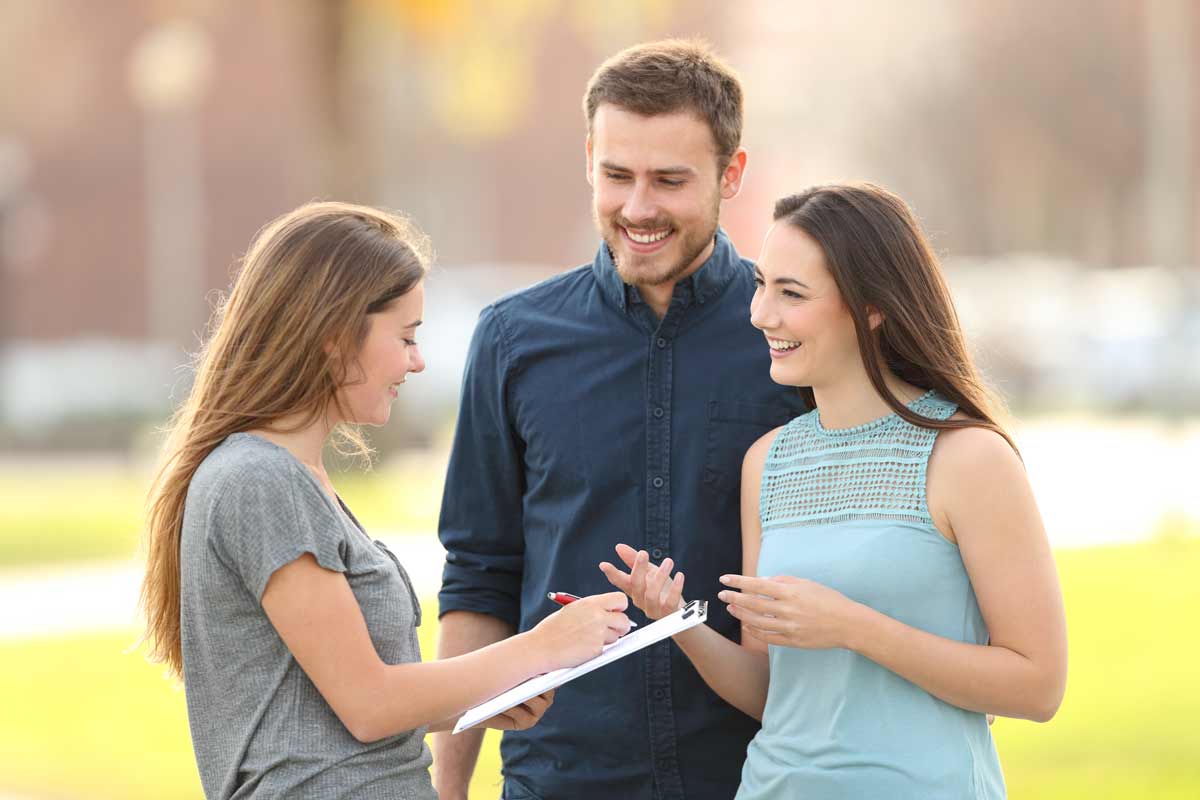 individual with clipboard talking to a couple