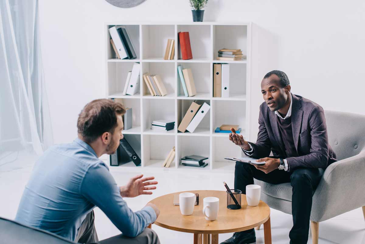 Counselor sits with client.