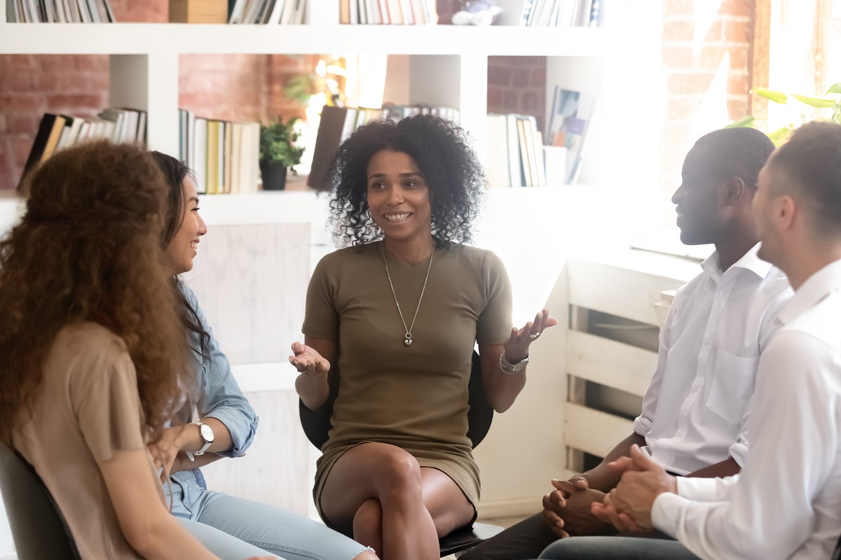 A group of young professionals sitting in a circle and talking
