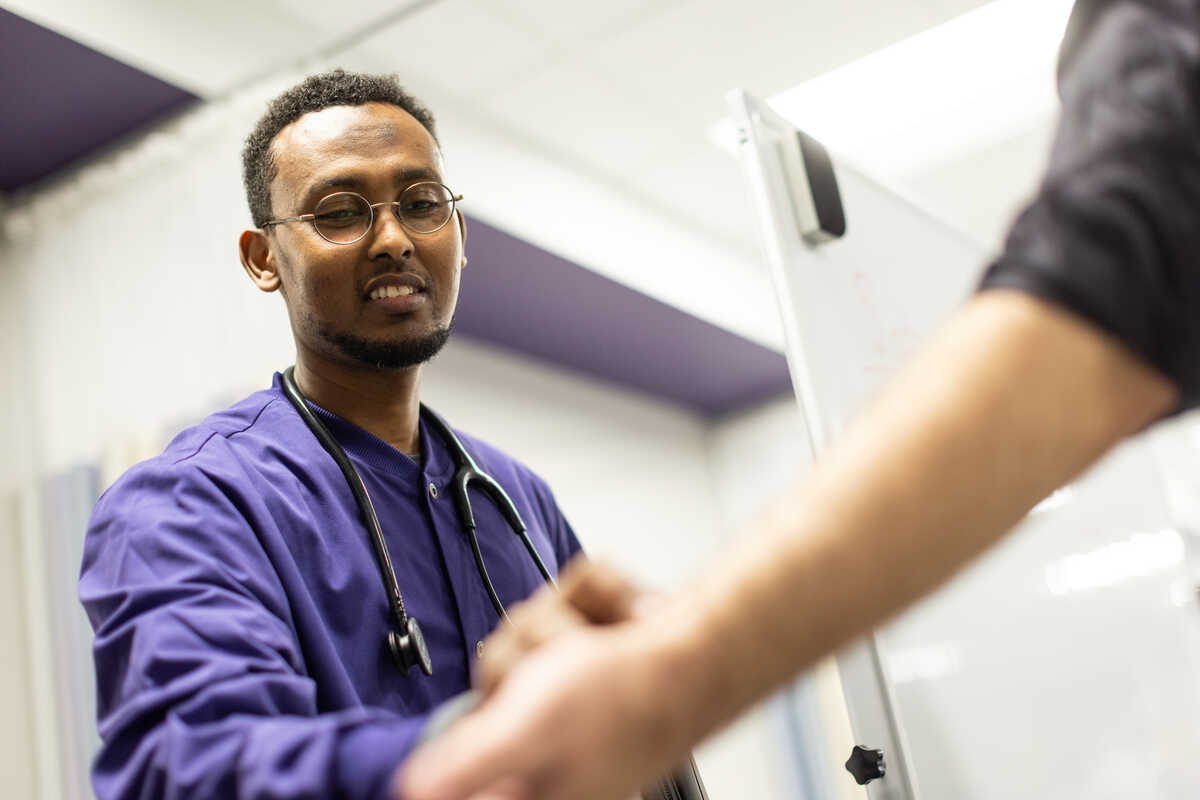 A man wearing St. Thomas nursing scrubs