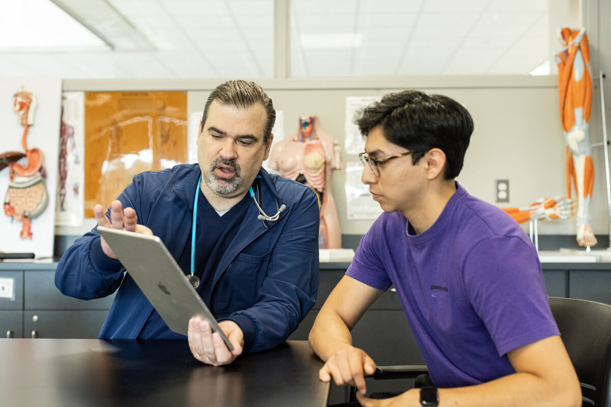 Professor showing tablet to student