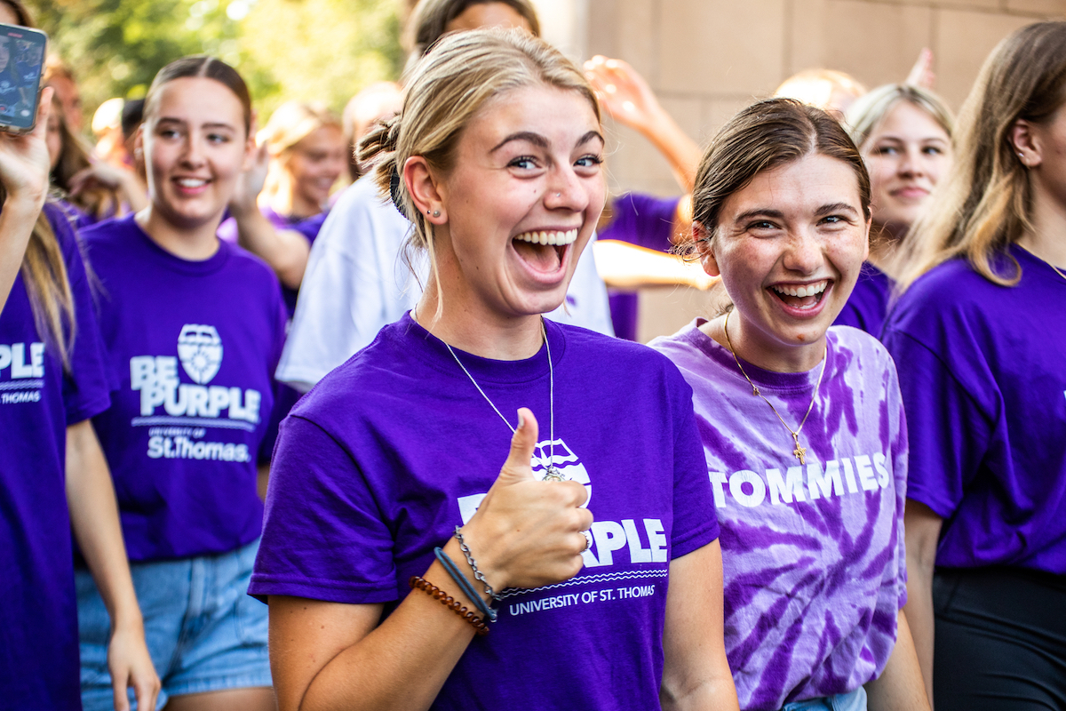 students smiling at the camera with thumbs up