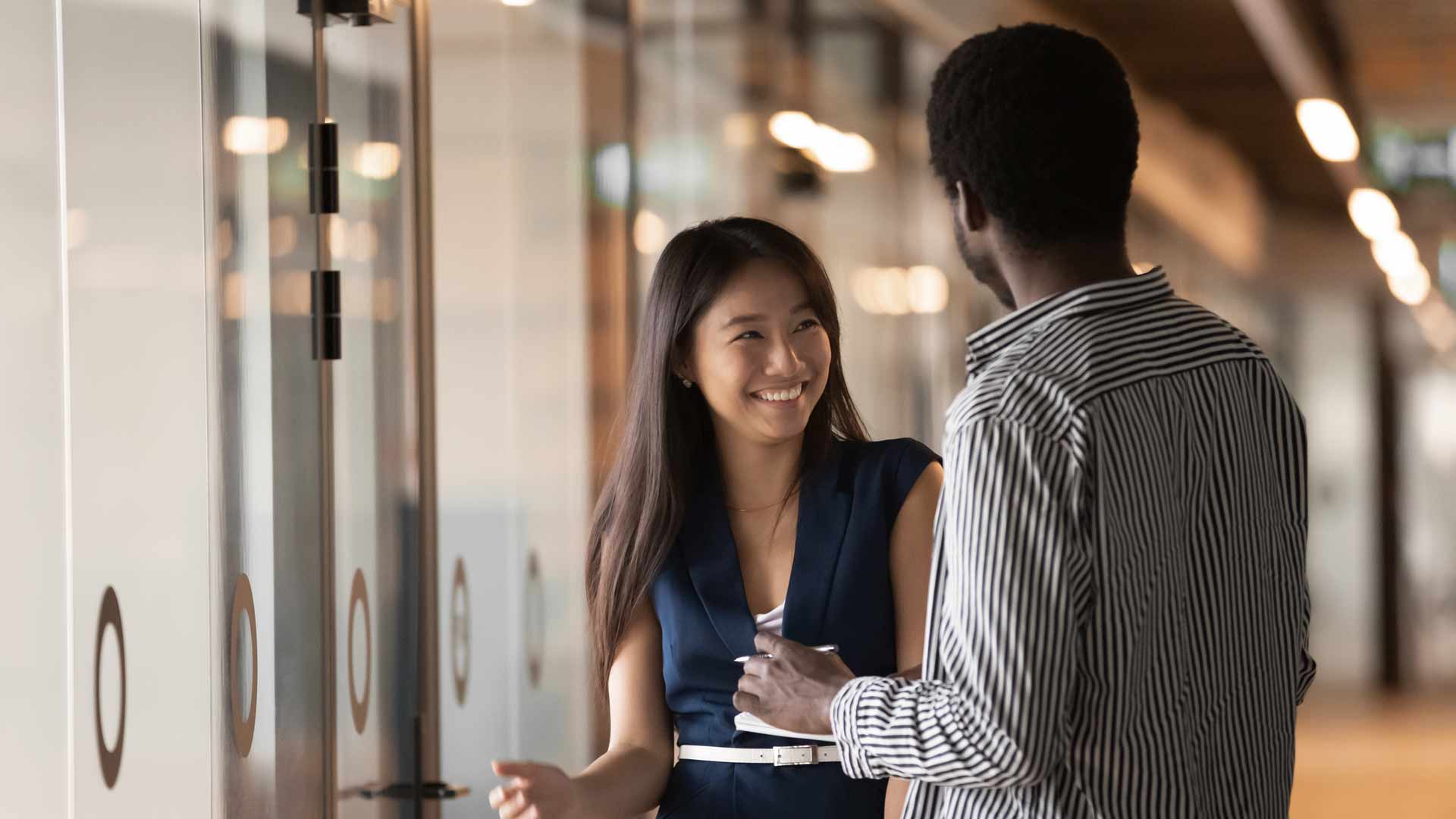 two individuals stand and talk