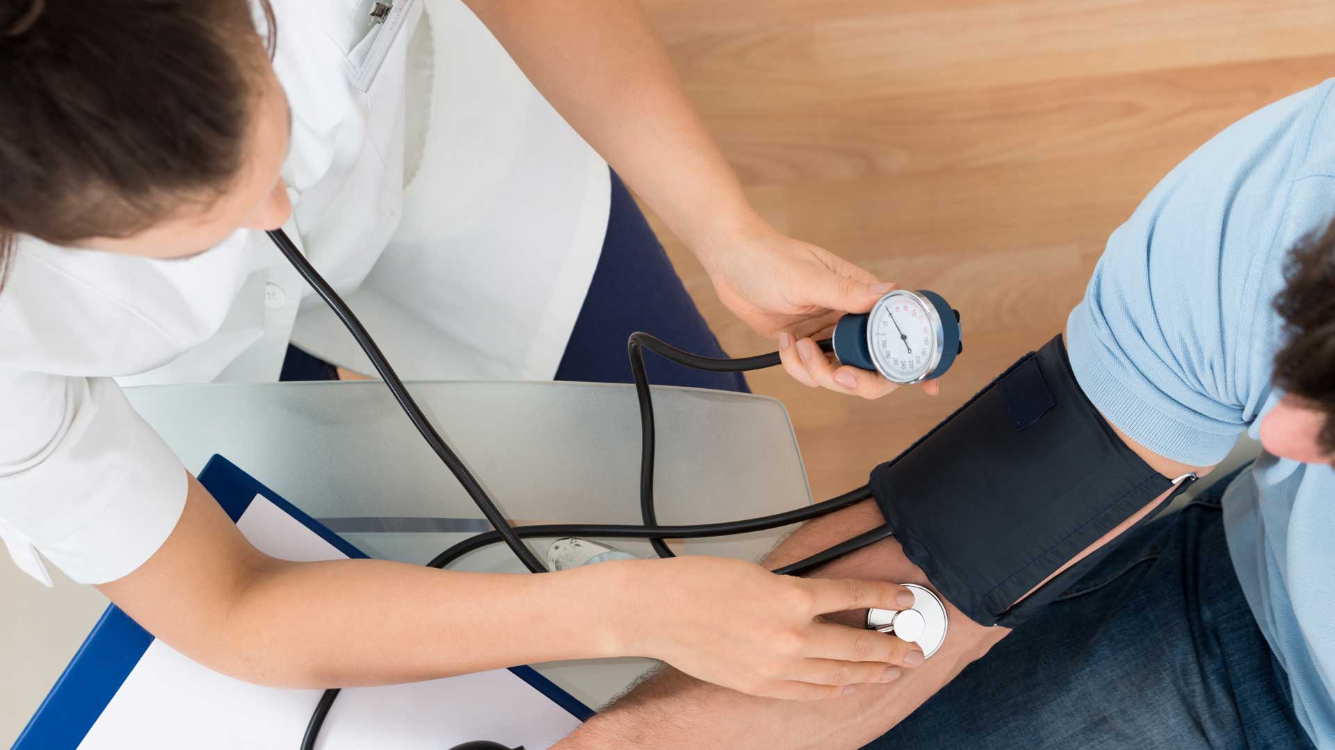 A nurse takes a patient's blood pressure.