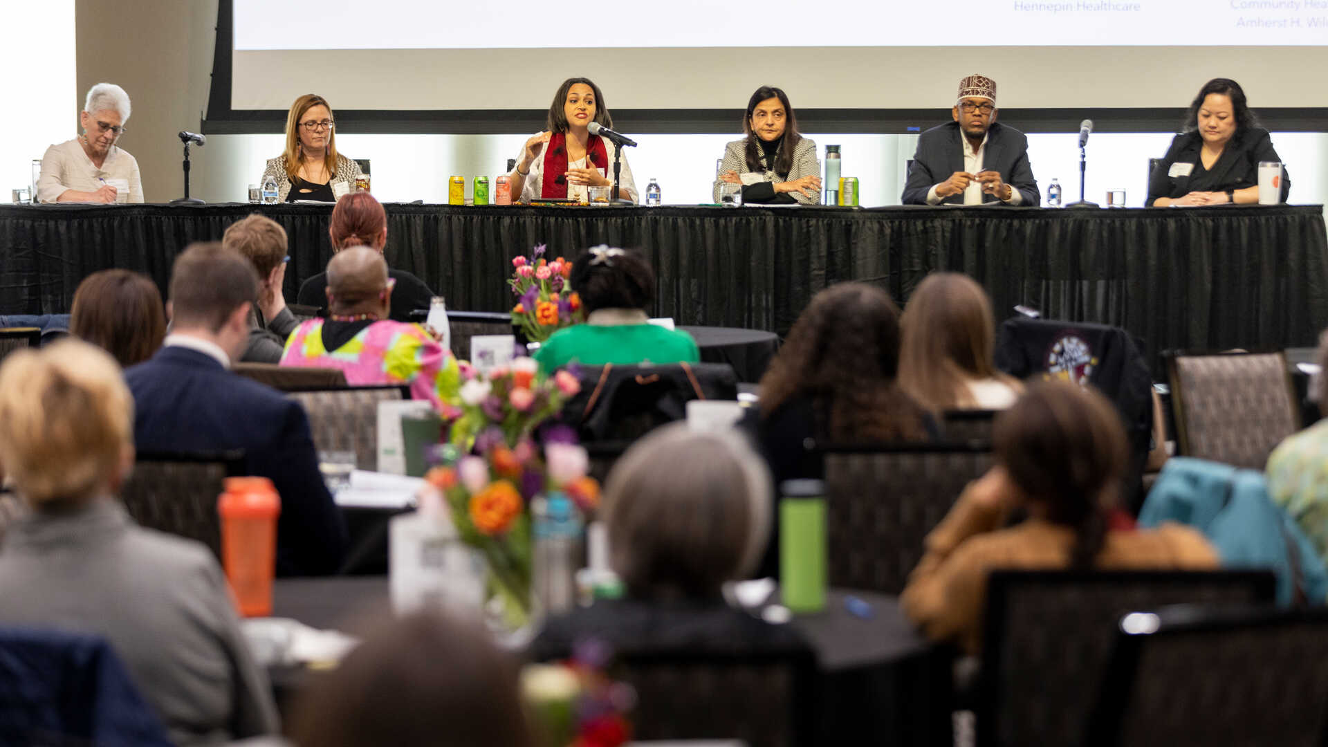 Panelists speak at a conference