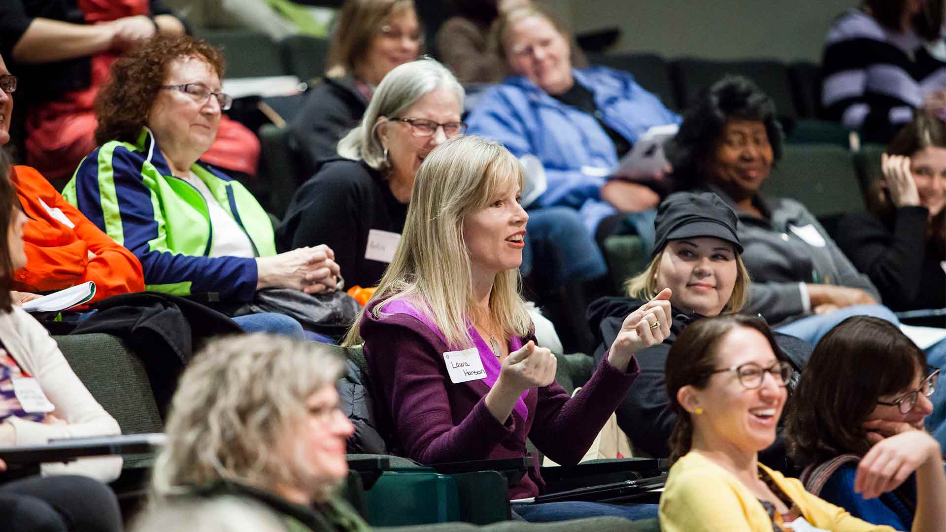 Individuals sitting in a lecture hall. 