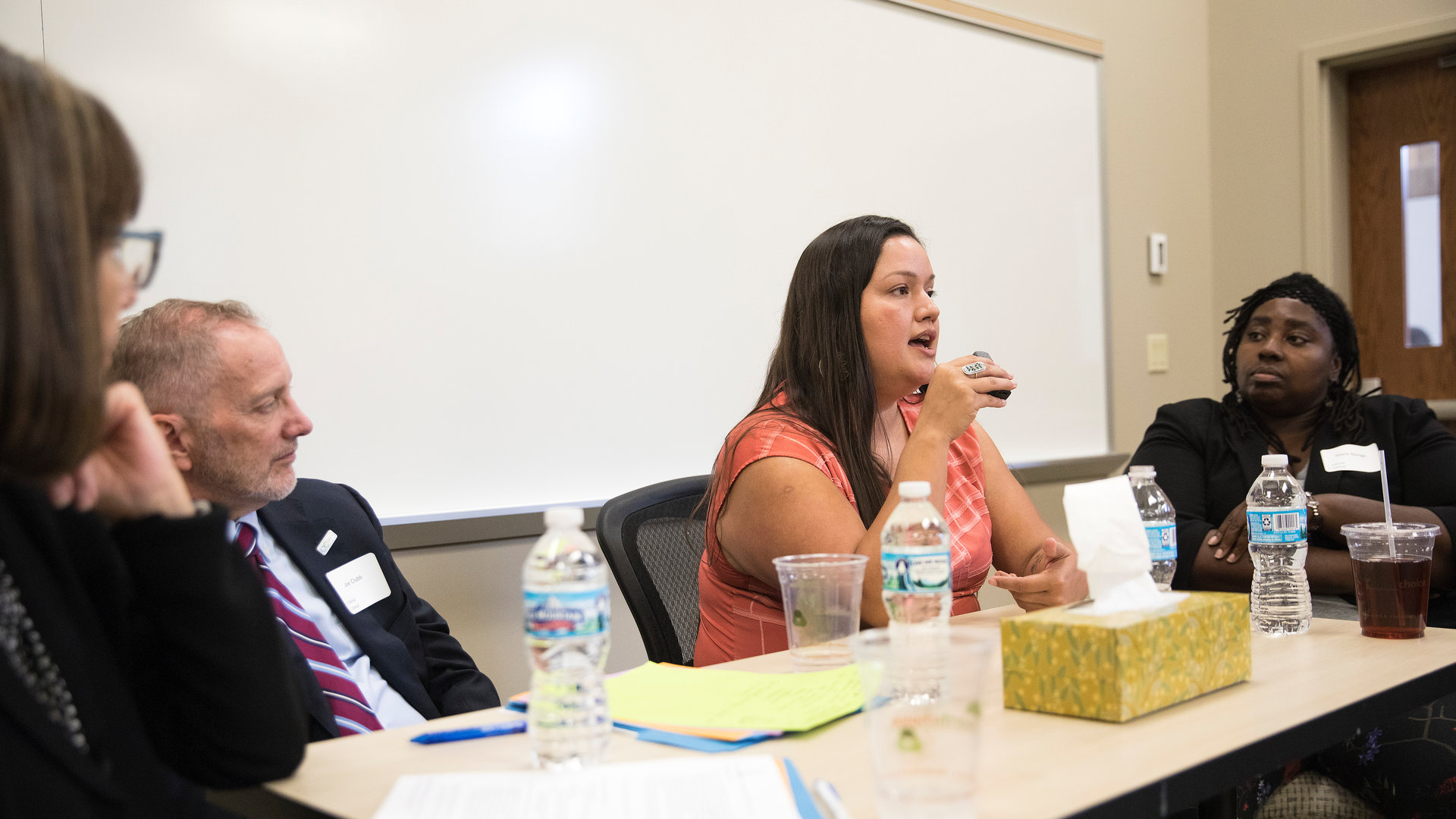 Students have a group discussion while sitting in a classroom.