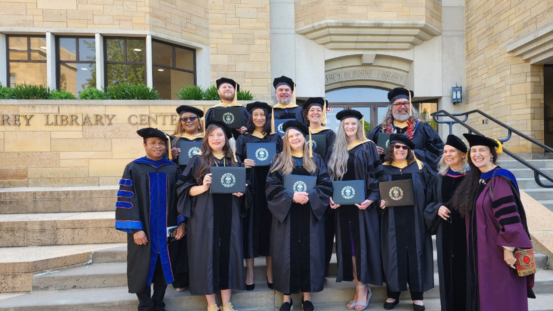 Doctorate graduates holding their degrees
