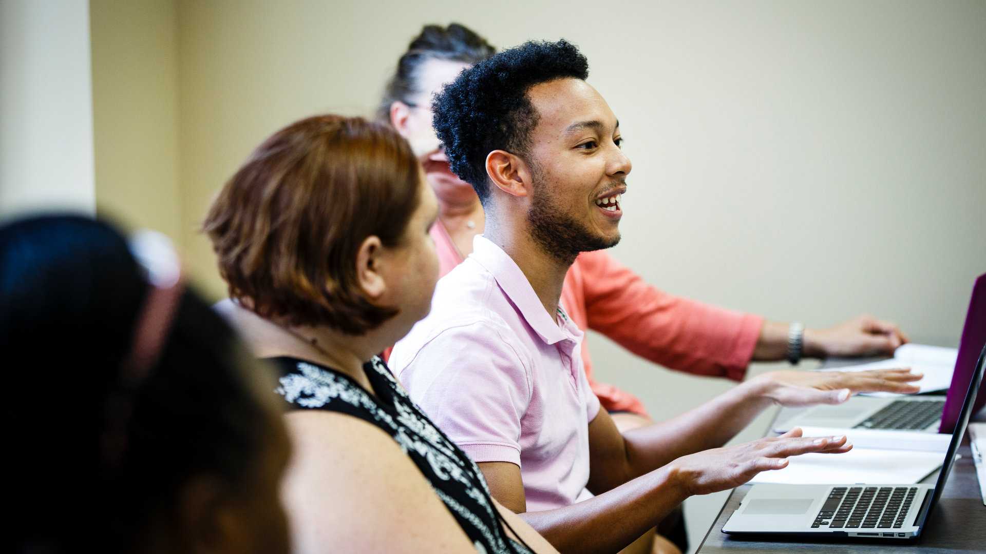 Students sitting at a long desk speak during a Doctorate of Social Work class.